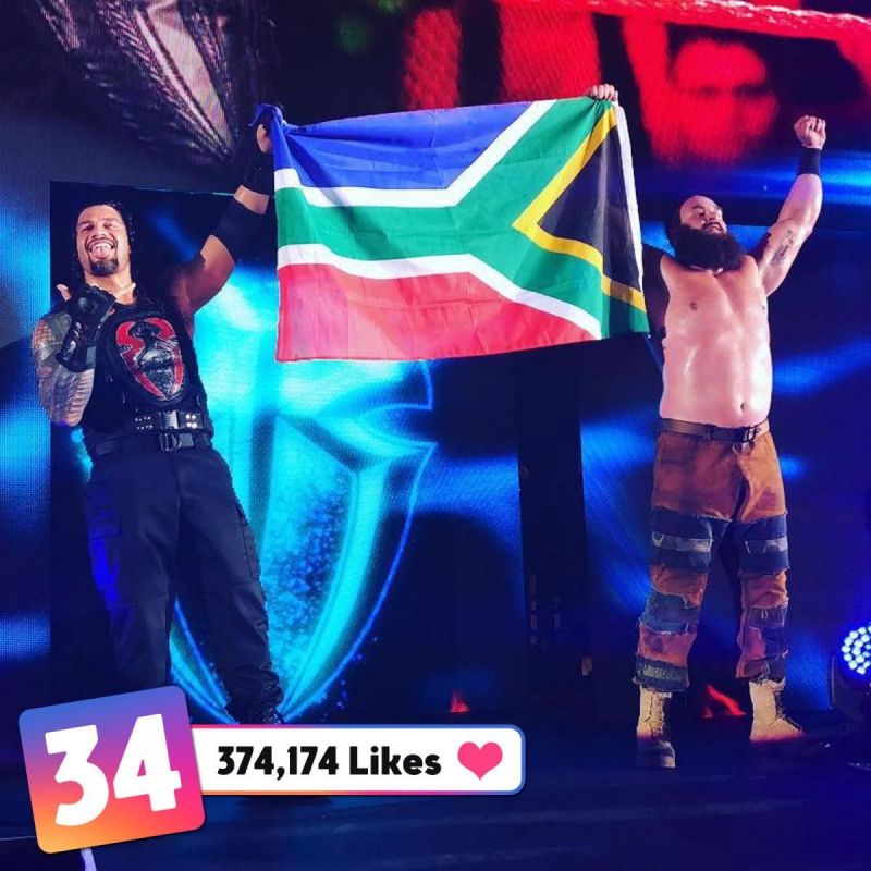 reigns and strowman posed at the top of the stage holding the south african flag - most followed instagram south africa