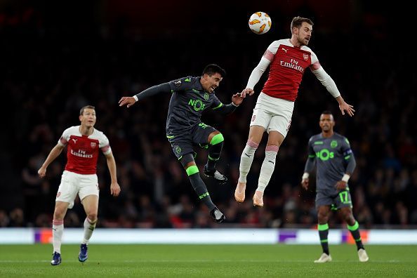 Aaron Ramsey tussling for possession in the air during Arsenal's Group E home clash against Sporting