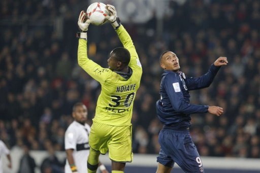 Rennes' goalkeeper Cheik Ndiaye (L) grabs the ball in front of Paris Saint-Germain's forward Guillaume Hoarau Rennes' goalkeeper Cheik Ndiaye (L) grabs the ball in front of Paris Saint-Germain's forward Guillaume Hoarau