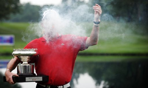 Miguel Angel Jimenez of Spain jokes with his cigar while posing with the trophy Miguel Angel Jimenez of Spain jokes with his cigar while posing with the trophy