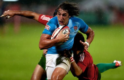 England's Dan Bibby (C) escapes a tackle by two Portuguese players England's Dan Bibby (C) escapes a tackle by two Portuguese players