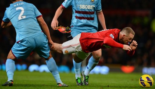 Manchester United's Wayne Rooney (R) falls as he fights for the ball with West Ham United's Winston Reid (L) Manchester United's Wayne Rooney (R) falls as he fights for the ball with West Ham United's Winston Reid (L)