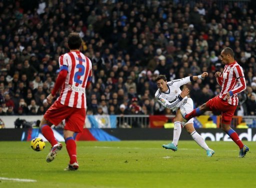 Real Madrid midfielder Mesut Ozil scores the second goal during their match against Atletico Madrid Real Madrid midfielder Mesut Ozil scores the second goal during their match against Atletico Madrid