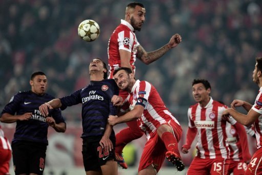 Olympiakos' Kostas Mitroglou (top) and Vassilis Torosidis (C) outmuscle Marouane Chamakh Olympiakos' Kostas Mitroglou (top) and Vassilis Torosidis (C) outmuscle Marouane Chamakh