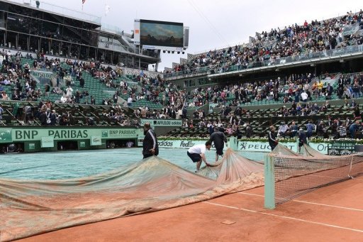 Staff remove the covers from Centre Court at Roland Garros on June 8, 2012 Staff remove the covers from Centre Court at Roland Garros on June 8, 2012