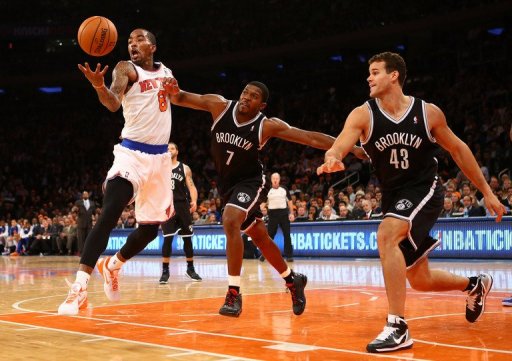 The Knicks' J.R. Smith (L) grabs a rebound as the Nets' Joe Johnson (C) defends during their game on December 19, 2012 The Knicks' J.R. Smith (L) grabs a rebound as the Nets' Joe Johnson (C) defends during their game on December 19, 2012
