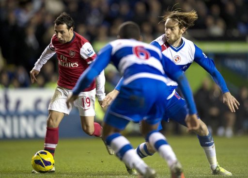 Arsenal's Santi Cazorla (L) fights for the ball with Reading's Kaspars Gorkss (R), in Reading, on December 17, 2012 Arsenal's Santi Cazorla (L) fights for the ball with Reading's Kaspars Gorkss (R), in Reading, on December 17, 2012