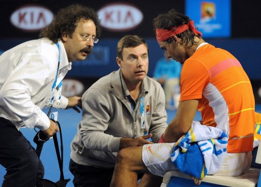 Courtside trainers attend to Rafael Nadal's knee injury during the Australian Open, in Melbourne, on January 26, 2010 Courtside trainers attend to Rafael Nadal's knee injury during the Australian Open, in Melbourne, on January 26, 2010