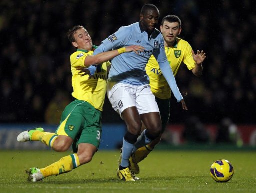 Norwich City's defender Steven Whittaker falls to the ground as he challenges Manchester City's midfielder Yaya Toure Norwich City's defender Steven Whittaker falls to the ground as he challenges Manchester City's midfielder Yaya Toure