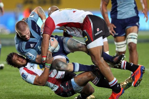 Blues' Gareth Anscombe is tackled by Lions' Elton Jantjies (L) and Lionel Mapoe (R), in Auckland, on May 11, 2012 Blues' Gareth Anscombe is tackled by Lions' Elton Jantjies (L) and Lionel Mapoe (R), in Auckland, on May 11, 2012