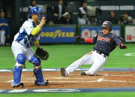 Japan's Seiichi Uchikawa (R) arrives at the home plate in Fukuoka on March 2, 2013 Japan's Seiichi Uchikawa (R) arrives at the home plate in Fukuoka on March 2, 2013