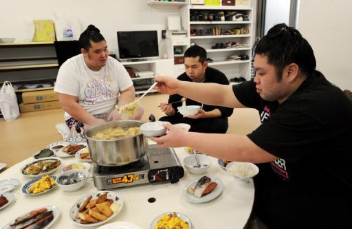 Sumo wrestlers Genkaiho (R) and Migikataagari (L) eat with hair dresser Tokonao at a sumo stable on February 14, 2013 Sumo wrestlers Genkaiho (R) and Migikataagari (L) eat with hair dresser Tokonao at a sumo stable on February 14, 2013
