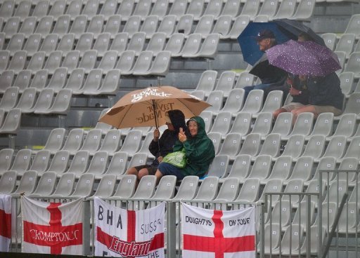 Fans take cover as poor light and rain prevented play on the first day of the opening Test on March 6, 2013 Fans take cover as poor light and rain prevented play on the first day of the opening Test on March 6, 2013