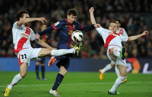 Lionel Messi (C) is blocked by Rayo Vallecano's Jordi Figueras Montel (L) and Tito during their match on March 17, 2013 Lionel Messi (C) is blocked by Rayo Vallecano's Jordi Figueras Montel (L) and Tito during their match on March 17, 2013