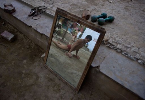 A budding Indian wrestler does push-ups at a traditional mud akhara in New Delhi on March 6, 2013 A budding Indian wrestler does push-ups at a traditional mud akhara in New Delhi on March 6, 2013