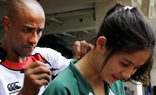 Australian rugby legend George Gregan signs the back of a fan's jersey in Hong Kong on March 22, 2011 Australian rugby legend George Gregan signs the back of a fan's jersey in Hong Kong on March 22, 2011