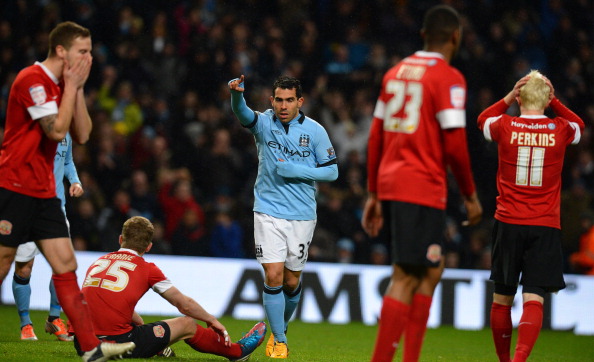 Manchester City's Argentinian forward Carlos Tevez (C) celebrates after scoring his team's fourth goal and his third to complete his hat-trick during the English FA Cup quarter-final football match between Manchester City and Barnsley at the Etihad Stadium in Manchester, north-west England, on March 9, 2013.