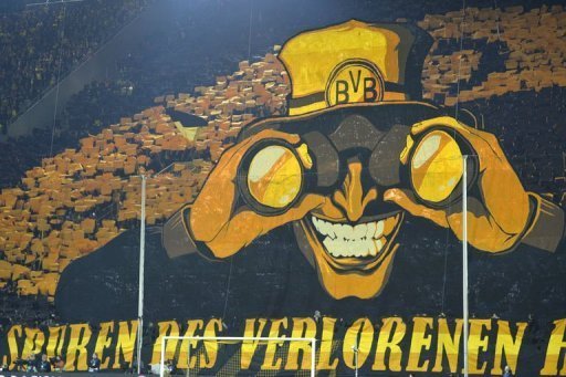 Dortmund's fans wave yellow colours behind a giant poster on April 9, 2013 Dortmund's fans wave yellow colours behind a giant poster on April 9, 2013