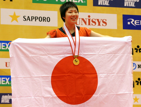 16-year-old Akane Yamaguchi of Japan (R) shows her national flag on the podium after her women's singles final at the Japan Open 2013 in Tokyo on September 22, 2013. (Getty Images)